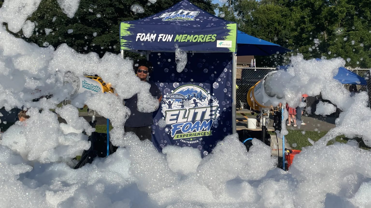 The Elite Foam Experiences branded tent and foam cannon set up at a Chattanooga area event, surrounded by foam